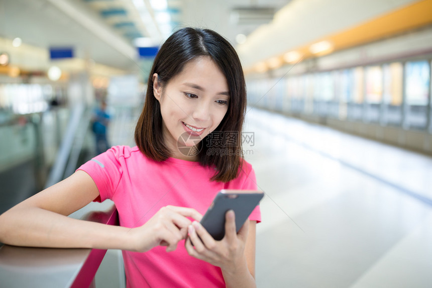 在火车平台上使用移动电话的亚洲图片