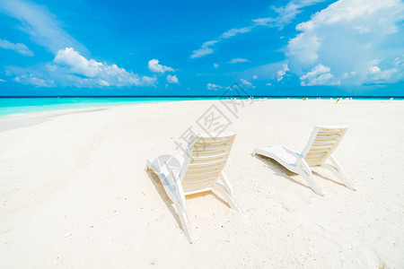 马尔代夫岛酒店度假村周围美丽的热带海滩和大海上的雨伞和椅子图片