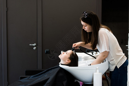 年轻女发型设计师在理发店用图片