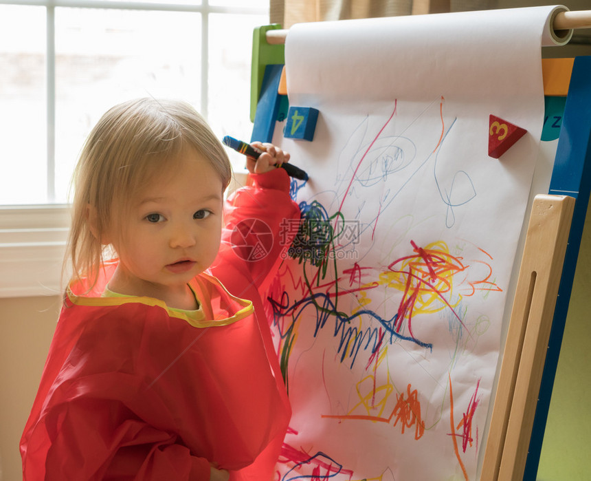玩耍时两岁女孩在纸上用蜡笔绘画纸上图片