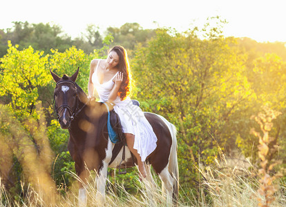 日落时骑马的年轻女子图片