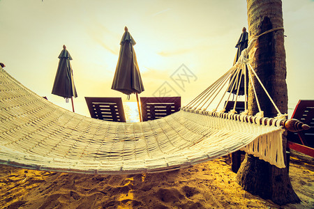 沙滩和海边空吊床日出时椰子棕榈树图片