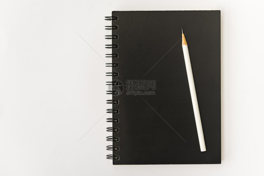白色铅笔与白色背景上的黑色笔记本图片