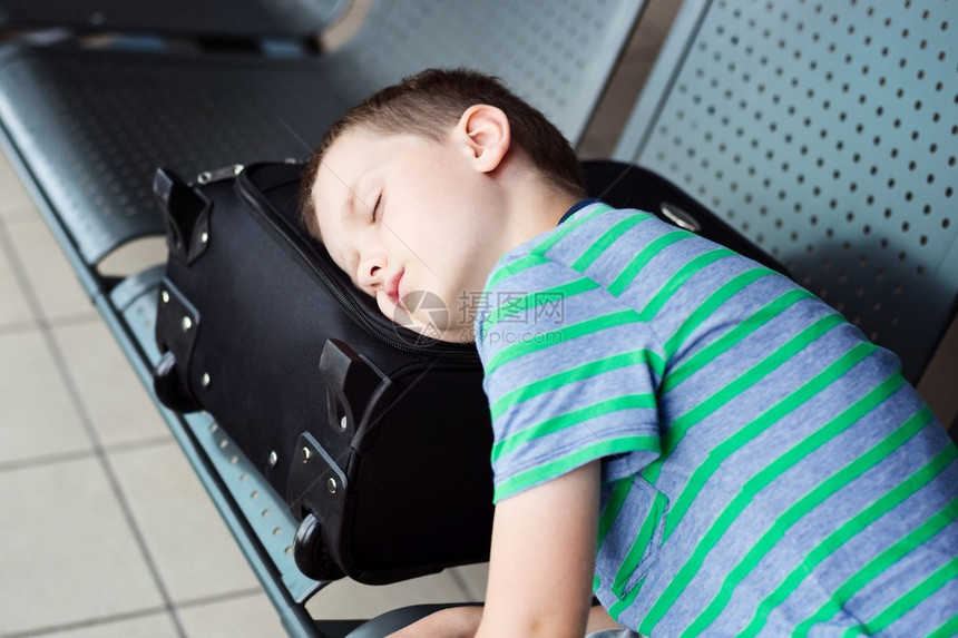 在机场睡觉的疲累儿童男孩图片