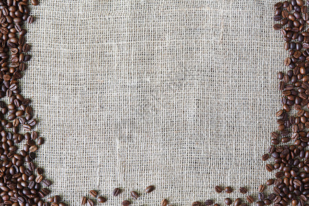 粗麻布质地与咖啡豆边框麻袋布粗麻布纹理背景棕色天然麻布帆背景与种子框架和复制空间在粗麻布纺织品的背景图片