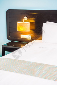 卧室内的床上白色枕头和墙壁装饰上的灯图片