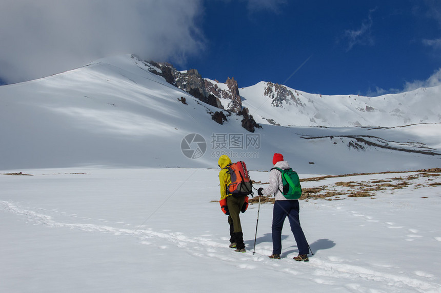 男和女登山者登上一座白雪皑的火山土耳其图片