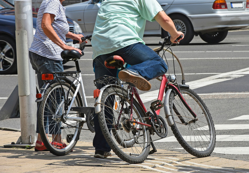 城市过马路的骑自行车的人图片