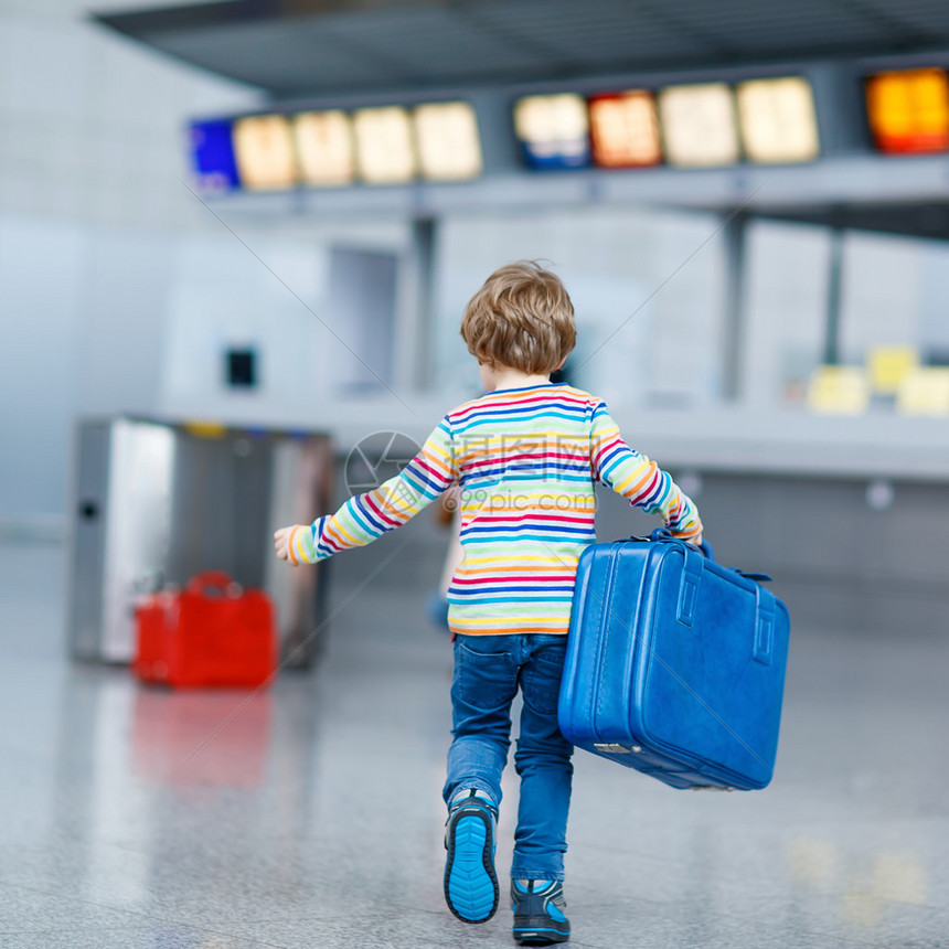 小小孩男孩与国际机场上的手提箱图片