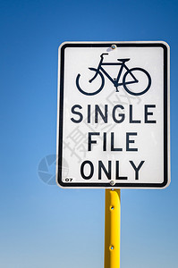 沿自行车道的白色警告标志敦促自行车留在图片