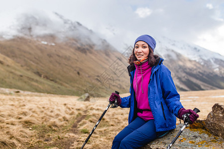 在高的雪山呼吸新鲜空气的女人图片