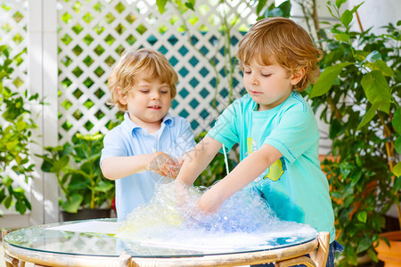 两个小男孩在玩耍玩得开心尝试多彩的肥皂泡图片