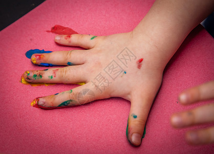 儿童手用水彩颜料在纸上制作彩色标记图片