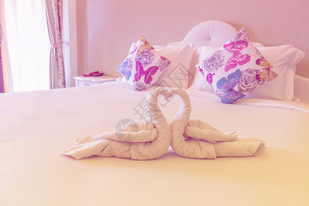 床边有天鹅形的折叠毛巾图片