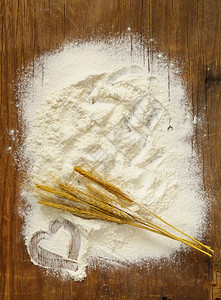 木桌上的面粉和麦穗图片