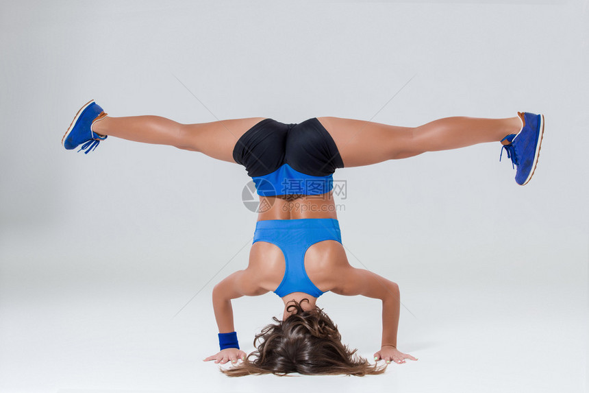 运动和积极的生活方式运动灵活的女孩健身女人穿着蓝色运动服在浅色背景图片