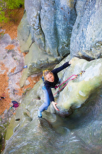女孩攀岩者在悬崖上攀登艰难的路线图片