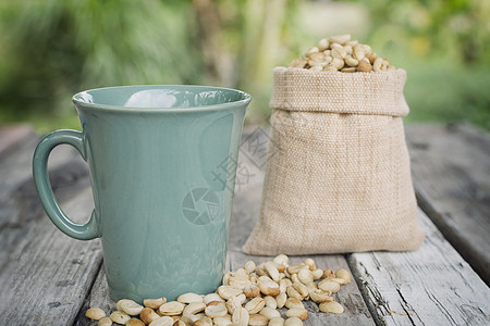 古老的调子杯和原始咖啡豆在木质图片