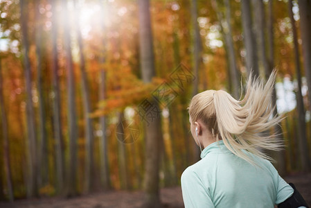 在秋天的森林里慢跑的女人在户外慢跑的梦幻天气图片