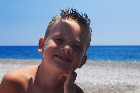 沙滩上的有趣孩子海边微笑的小男孩图片