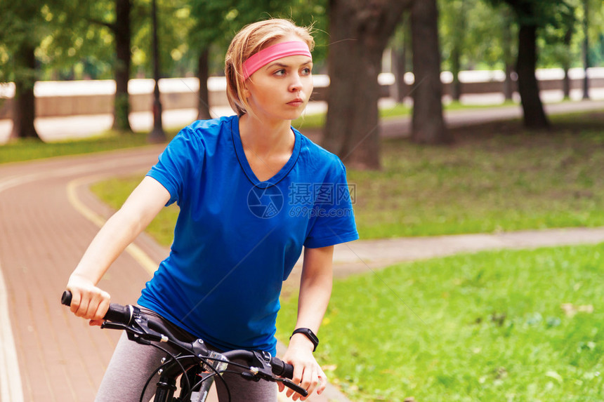 在公园里骑自行车的年轻美女活跃人图片