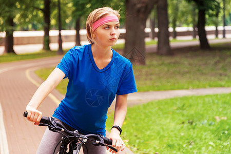 在公园里骑自行车的年轻美女活跃人背景图片