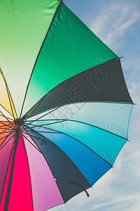 在蓝天背景下打开五颜六色的彩虹伞图片