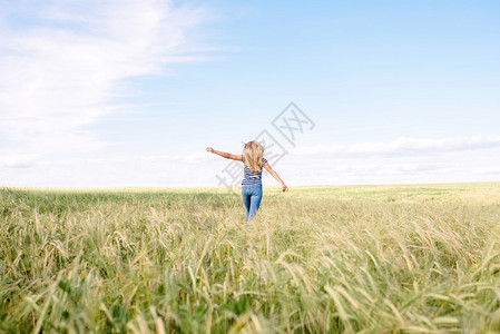 快乐的女孩跑过田野图片