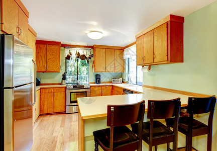 明亮的厨房有浅棕色柜子钢铁器图片