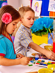 两个孩子女孩和男孩在小学的桌子上用毛笔绘画小图片
