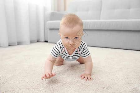 可爱的小宝在轻薄的地毯上爬行图片