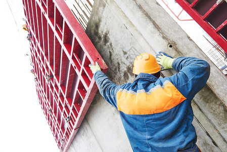 建筑工人在建筑工地拆卸脚手架施工图片