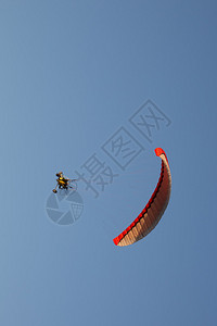 机动滑翔伞在夏日飞越山峰图片