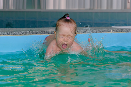小女孩在游泳池里跳水图片