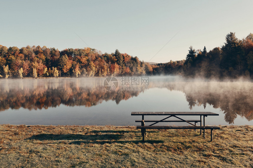 湖雾与秋叶树和山峰反射在新图片