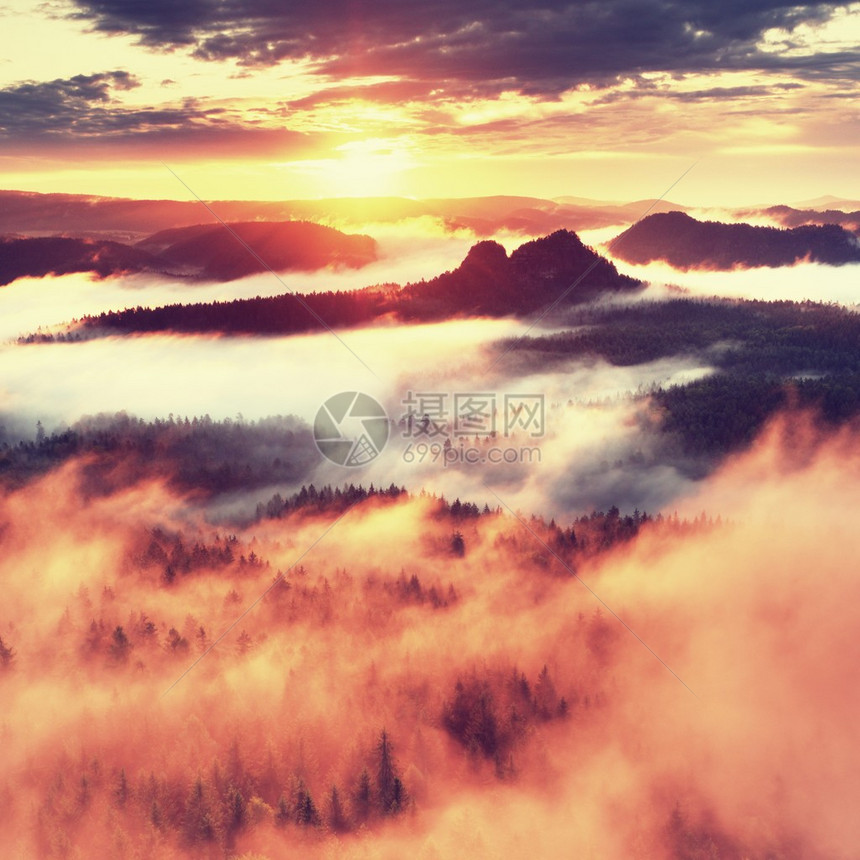 红色滤镜照片红色黎明朦胧的黎明在美丽的小山峰从有雾的背景中伸出图片