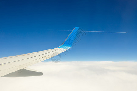 蓝天背景的云上方飞行的图片