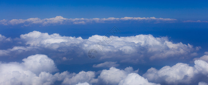 白云漂浮在湛蓝的天空中的全景图片