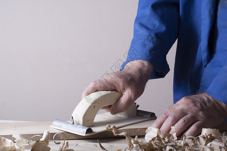 木匠在建筑工地的木制背景上使用飞机图片