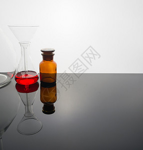 玻璃桌上的实验室玻璃器件有温暖和白图片