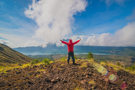 青年男子站在山顶上举起手来图片