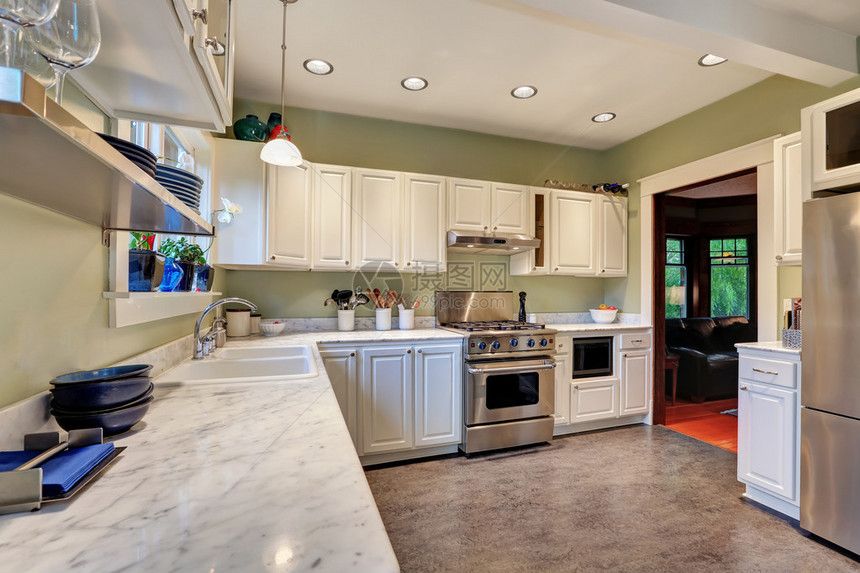 厨房内设计有白色柜子大理石柜顶不锈钢器和小木质楼层的明亮图片