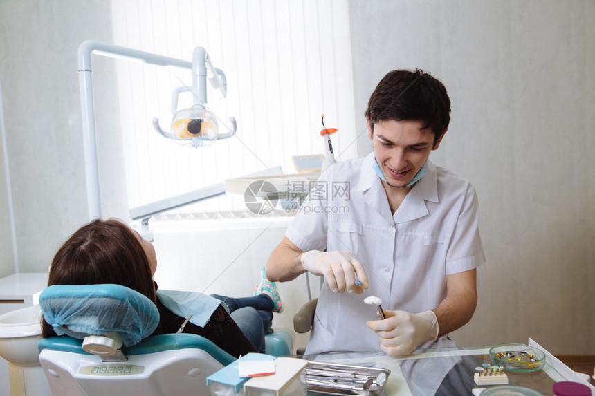 专业牙医对女病人牙科手术进行牙齿检查图片