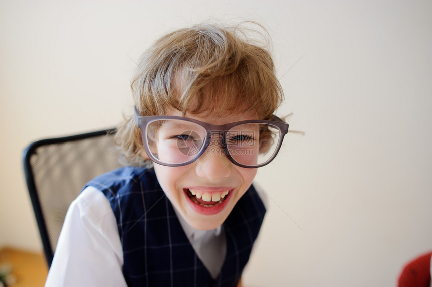 戴着大眼镜的滑稽小男生漫不经心地笑着他心情很好图片
