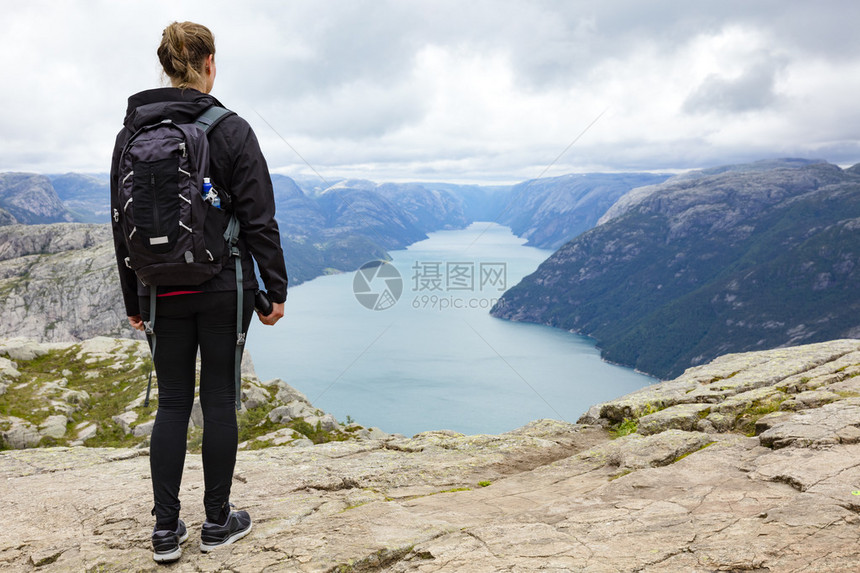 戏剧云彩和在Prekestolen远足的女游客Preikestolen也以PreachersPulpit或Rock的英文翻译而闻图片