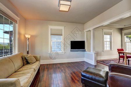 现代房子明亮的米色客厅内部配有沙发棕色皮革扶手椅和黑色脚凳塔科马图片