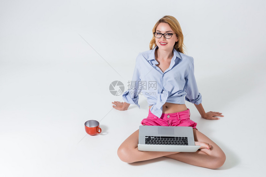 坐在地板上双腿交叉的年轻女士图片