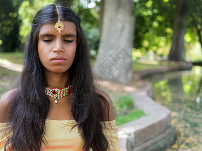 美丽的年轻印度女人在公园里练习冥想正念概印度教宗图片