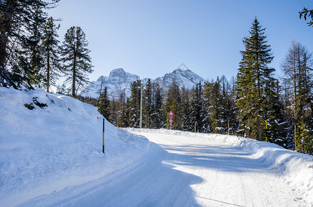 明冬日雪中覆盖的危险风山路图片