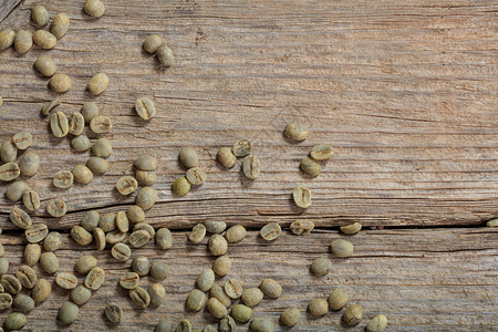 木制背景上的绿色咖啡豆图片